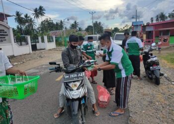 Pakai Sarung Khas Nahdliyin, PAC GP Ansor Posigadan Bagikan Takjil dan Masker