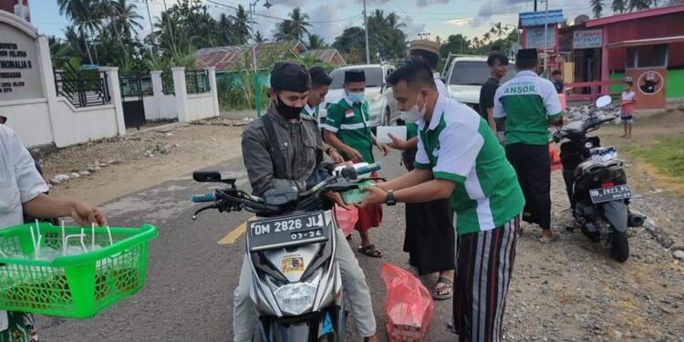 Pakai Sarung Khas Nahdliyin, PAC GP Ansor Posigadan Bagikan Takjil dan Masker
