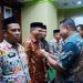 Bupati Depri Pontoh saat memakaikan Lambang Garuda kepada Pjs Sangadi (Foto : Istimewa)