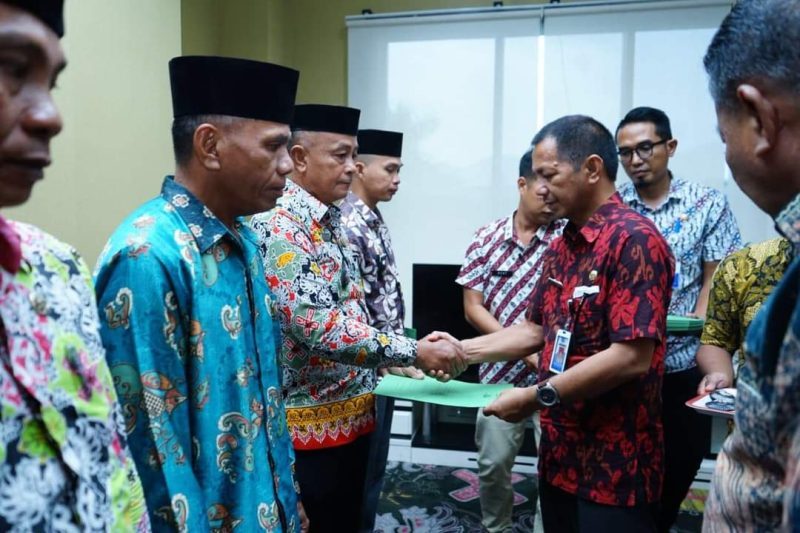 Sekretaris Daerah Jusnan C. Mokoginta saat menyerahkan SK kepada Pjs Sangadi.