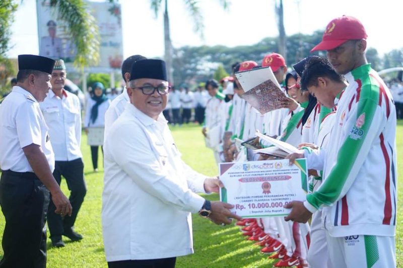 Wakil Bupati Bolmut, Drs. H. Amin Lasena, saat menyerahkan penghargaan bagi atlet