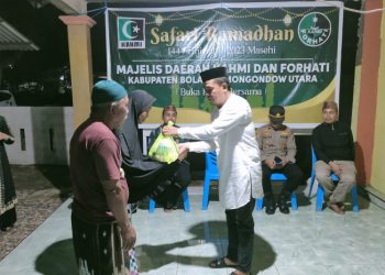 Koordinator MD KAHMI Bolmut, Dr. Arter Datunsolang, M.Si, saat menyerahkan bantuan kepada masyarakat. (Foto : Istimewa)