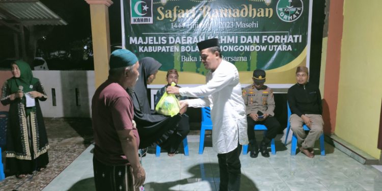Koordinator MD KAHMI Bolmut, Dr. Arter Datunsolang, M.Si, saat menyerahkan bantuan kepada masyarakat. (Foto : Istimewa)