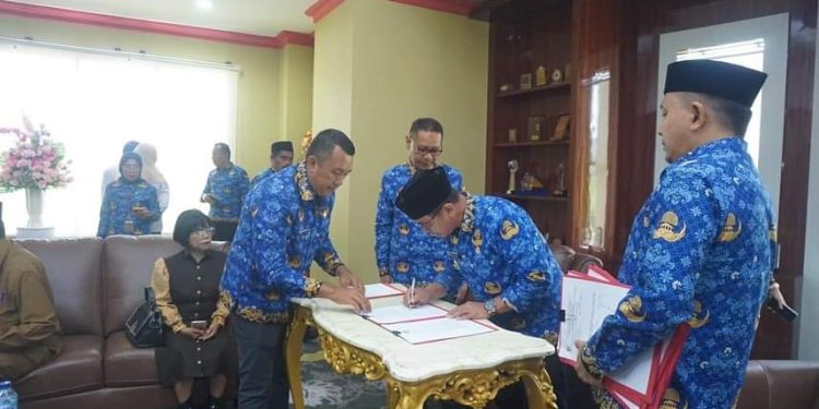 Foto : Pj Bupati Bolmut, Sirajudin Lasena, saat menandatangani SK Pengangkatan Staf Khusus Bupati