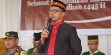 Foto : Pj Bupati Bolmut, Sirajudin Lasena, saat menyampaikan sambutannya dalam tradisi Mopohabaru