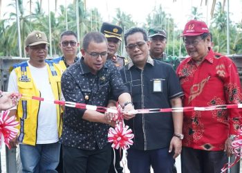 Foto : Pj Bupati Bolmut, Sirajudin Lasena saat melakukan pengguntingan pita pada peresmian Jembatan Gantung Goyo