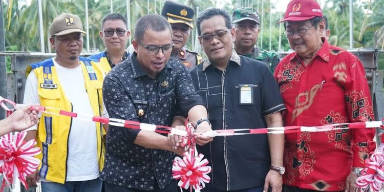 Foto : Pj Bupati Bolmut, Sirajudin Lasena saat melakukan pengguntingan pita pada peresmian Jembatan Gantung Goyo