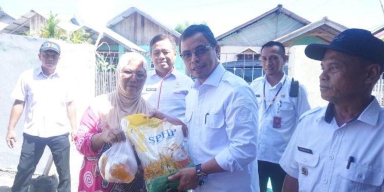Foto : Pj Bupati Bolmut, Sirajudin Lasena, saat memberikan sembako pada giat pasar murah