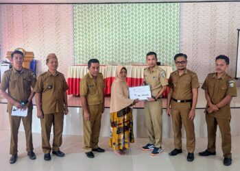 Foto : Wabup Bolmut, Mohamad Aditya Pontoh, saat menyerahkan langsung BLT di Desa Tombulang Pantai