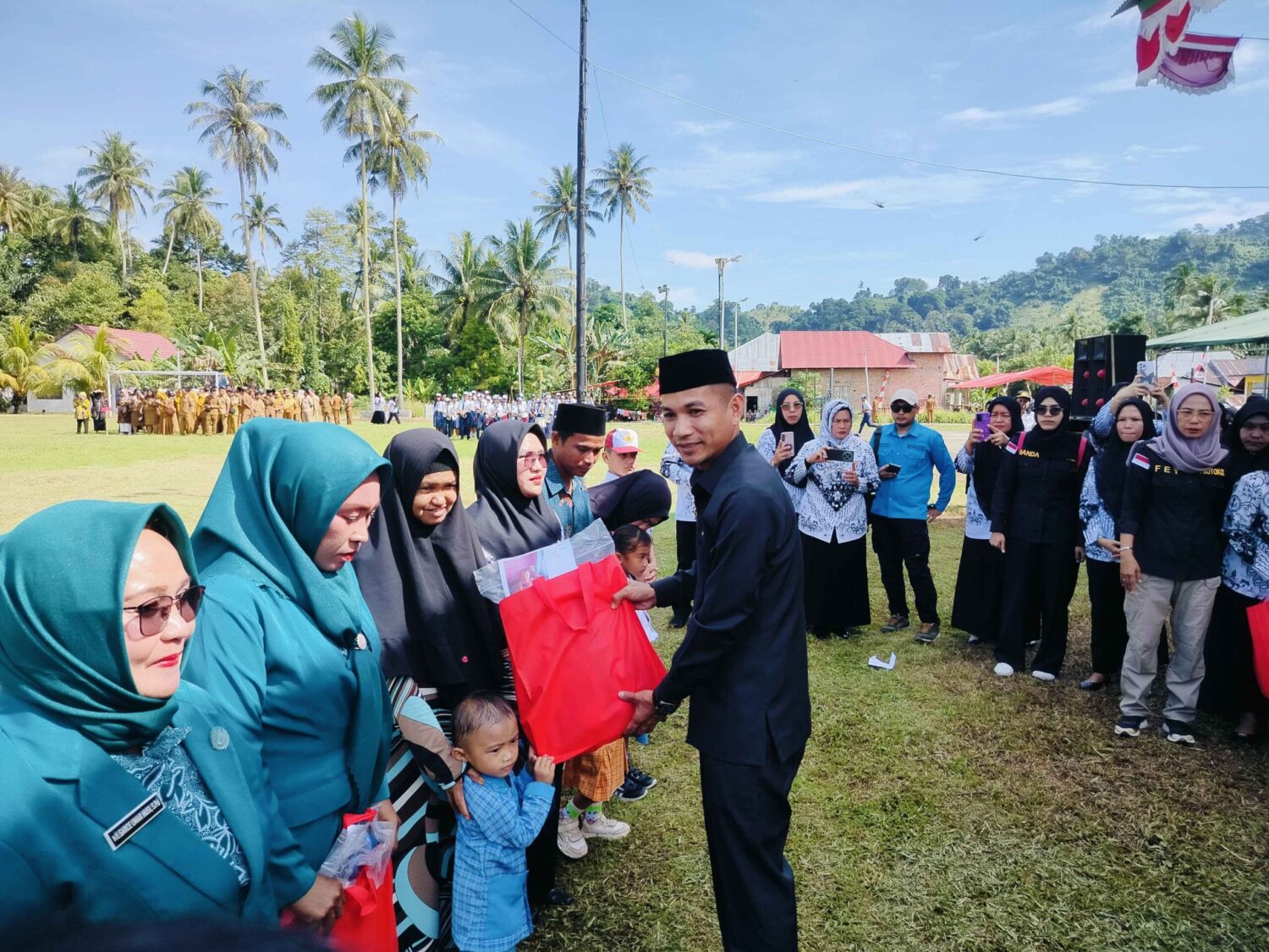 Foto : Wakil Bupati Boltara saat menyerahkan bingkisan kepada ibu-ibu PKK pada momentum Hardiknas