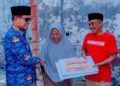 Foto : Bupati Boltara, Sirajudin Lasena, saat menyerahkan bantuan Pemda untuk korban kebakaran rumah di Desa Boroko Timur