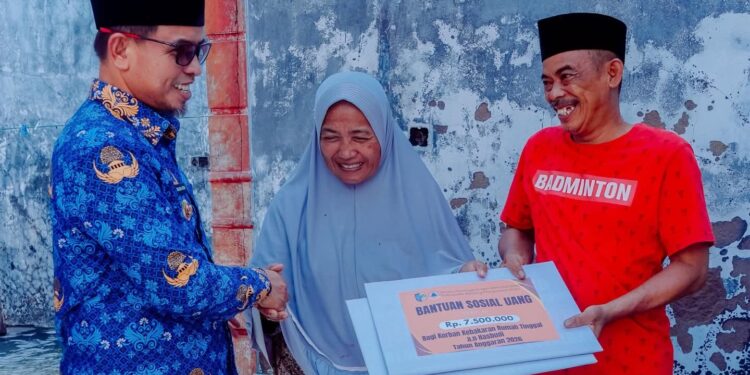 Foto : Bupati Boltara, Sirajudin Lasena, saat menyerahkan bantuan Pemda untuk korban kebakaran rumah di Desa Boroko Timur
